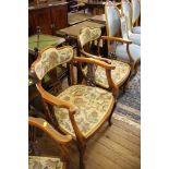 A pair of Edwardian stained beech open armchairs with shaped upholstered top rails, pierced vase