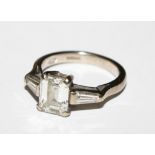 A fine diamond ring having an emerald cut diamond 7mm x 5mm with baguette diamond shoulders set in