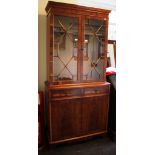 A yewwood veneer bookcase cabinet with astragal glazed doors over two frieze drawers and cupboard
