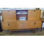 A G-Plan teak sideboard, with open central shelves, fall front to one side, sliding door to the