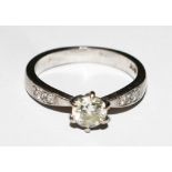 A single stone diamond ring with diamond shoulders set in 18 carat white gold