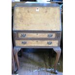 A walnut bureau, with burr walnut fall and two long drawers on carved cabriole legs and club feet,