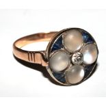 An Art Deco ring set with moonstones, sapphires and a centre diamond set in gold colour metal