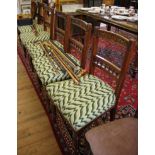 A set of six Edwardian walnut dining chairs, with fruit and rosette carved top rails above turned