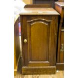 An Edwardian bedside cupboard, with panelled door on a plinth base, 40cm wide