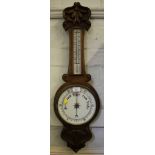 An Edwardian oak banjo barometer, carved with foliate scrolls, mercury thermometer, 85cm high