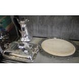 A silver plated entree dish, a bread board and a water jug