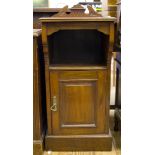 An Edwardian walnut bedside cabinet, the overhanging top above an open compartment and panelled door