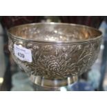 A Chinese silver rose bowl decorated in relief with flowers, signed to base "90 Chongwi Hong Kong