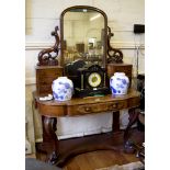 A mid Victorian mahogany dressing table, with arched plate on pierced scroll supports and six