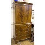 A flame mahogany serpentine side cabinet, with panelled doors over a slide, drawer and cupboard door