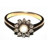 An pearl and diamond cluster ring set in gold colour metal