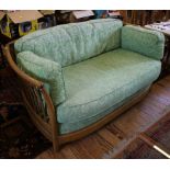 An Ercol oak framed two seat settee with rail back and arms, 148cm wide