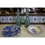 A pair of green overlay decanters and stoppers with floral faceted decoration, 34cm high, a blue and