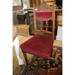 A set of four Edwardian walnut dining chairs, the carved and upholstered backs above stuffover seats