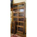 A 1920's oak stacking bookcase, each of the seven graduated sections with a pair of glazed doors