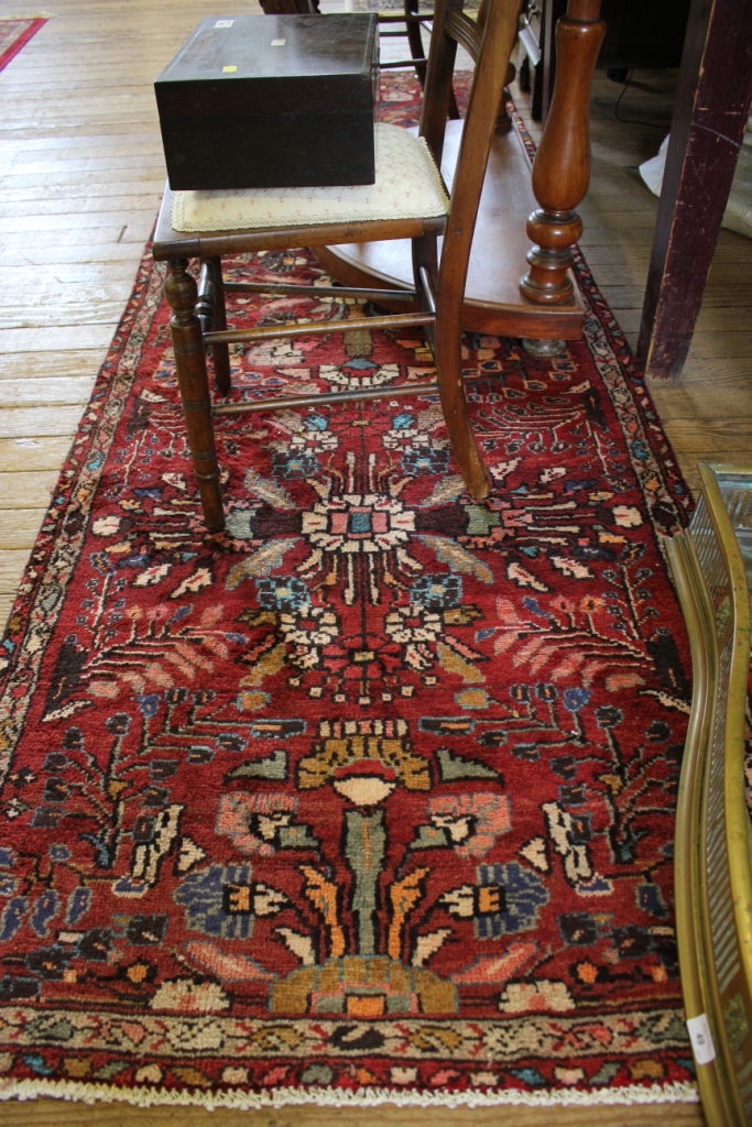 A Persian Hamadan runner, the full pile red field with flowers within a narrow border, 286cm x 97cm