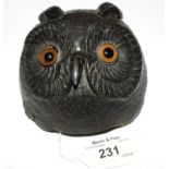 A bronze alloy table bell in the form of an owl head, with glass eyes, clockwork mechanism