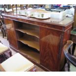 A crossbanded mahogany side cabinet, the open centre with serpentine shelves flanked by cupboard