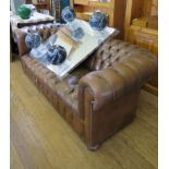 A brown leather Chesterfield sofa on turned feet, 200cm wide
