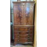 A flame mahogany serpentine side cabinet, with panelled doors over a slide, drawer and cupboard door