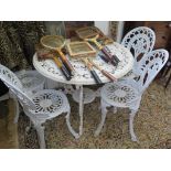 A painted metal Victorian style garden table with pierced beaded top and four scrolling legs