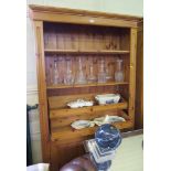 A pine open bookcase, with adjustable and pull-out shelves over a pair of cupboard doors, 114cm