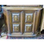 A Spanish style oak cabinet, with canted corners and heavily carved cupboard doors, 101cm wide