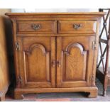 A small oak side cabinet, with short drawers over arch panelled doors on bracket feet, 77cm wide
