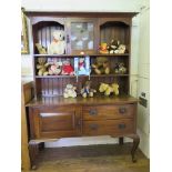 An Edwardian oak dresser and rack, the moulded cornice over a central lead glazed door surrounded by