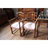 A pair of early 20th century oak carver chairs, the shaped top rails over lattice backs and scroll