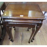 A nest of three mahogany tables, with inset glass tops and cabriole legs, 53cm wide