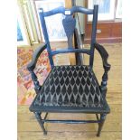 A pair of Edwardian ebonised open armchairs, the scroll top rails over vase shaped splats,