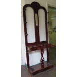 A mahogany hall stand, with central blindfret carved mirror, open back and hinged compartment over a