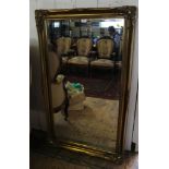 A Victorian style giltwood wall mirror, with bevelled plate and shaped frame with foliate cabochon