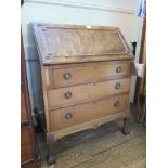 A mahogany bureau, the rosette carved fall front over three graduated drawers on carved cabriole