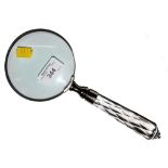 A silver plated magnifying glass with cut glass handle