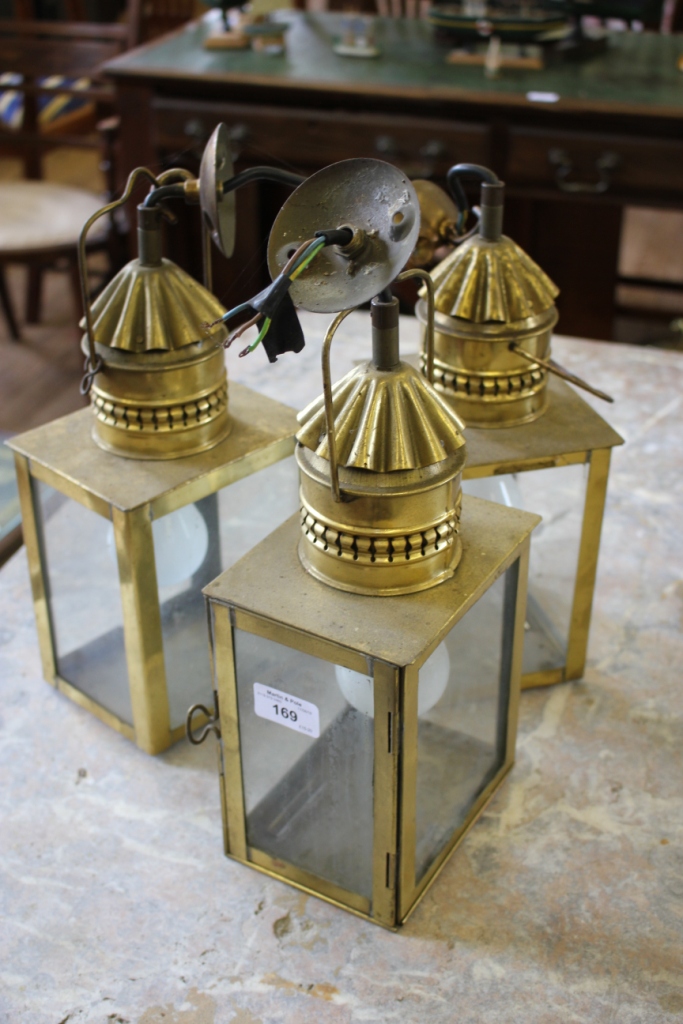 A set of three brass carriage lamps, of rectangular form, 34cm high