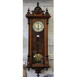 An early 20th century walnut and ebonised Vienna wall clock, the pediment with mask and finials over