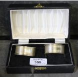 A cased pair of silver napkin rings