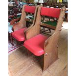 A pair of 1950's teak ecclesiastical style armchairs, of planked and peg construction with