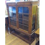 An oak display cabinet, with glazed doors and sides on barley-twist legs joined by stretchers, 102cm