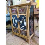 A Chinese style lacquer and oak side cabinet, the top with raised sides over a pair of panelled