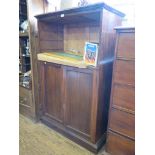 A mahogany bookcase cabinet, the open compartment over a pair of panelled doors on a plinth base,