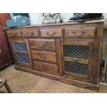 An Indian hardwood sideboard, with four short drawers over three central drawers flanked by metal