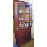 A pair of yew wood corner display cabinets, each with dentil cornice over a pair of glazed doors and