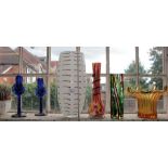 A pair of blue glass candlesticks, a large white vase, and three other coloured glass vases