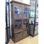 An oak standing bookcase by E.S.A. Esavian, the moulded cornice over three units with lead glazed