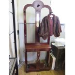 A mahogany hall stand, with central blindfret carved mirror, open back and hinged compartment over a