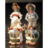 A pair of 19th century French figures of a boy and girl with a dog and sheep at their feet 24cm high